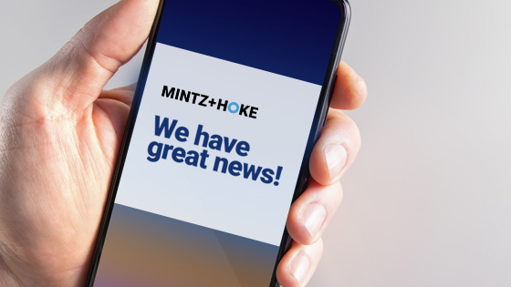 a message over a cell phone screen that reads Mintz and Hoke we have great news